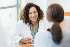 A woman speaking with a physician at a primary care medical center.