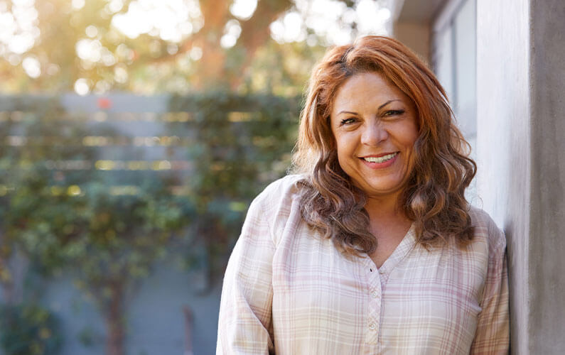 Older woman smiling outside.