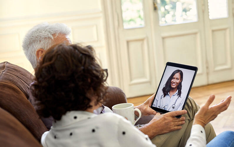 Patients using a tablet to talk to their doctor through a telemedicine appointment.