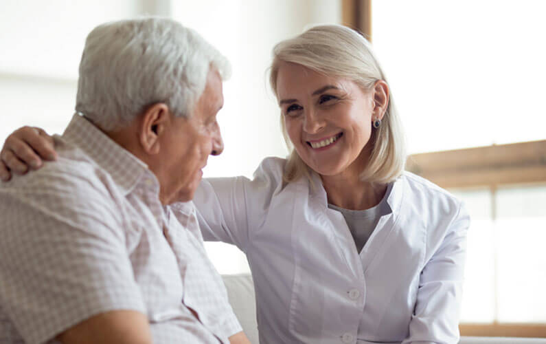 Woman healthcare provider consoling her male patient.