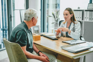 male senior talking to a Medicare provider in an office clinic