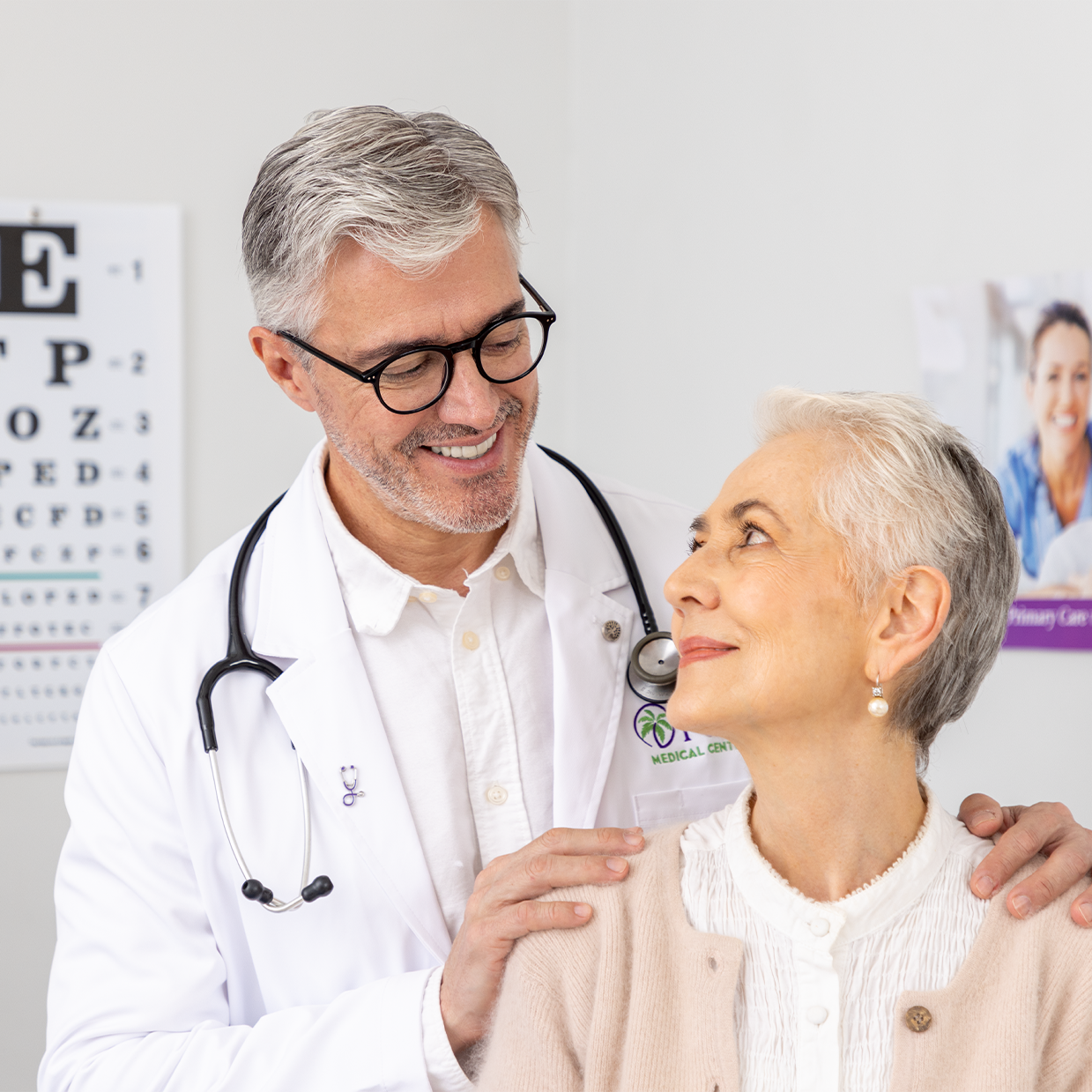 A male primary care doctor looking happily at his patient.