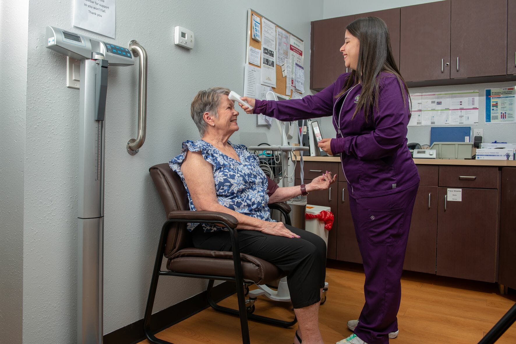 A nurse taking her patient's temperature.