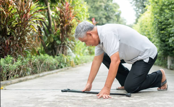 Asian senior man falling down at home in the backyard caused by myasthenia (Muscle Weakness) and the nurse came to help support. Concept of old elderly insurance and health care