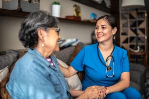 nurse woman talking with senior patient woman at nursing home