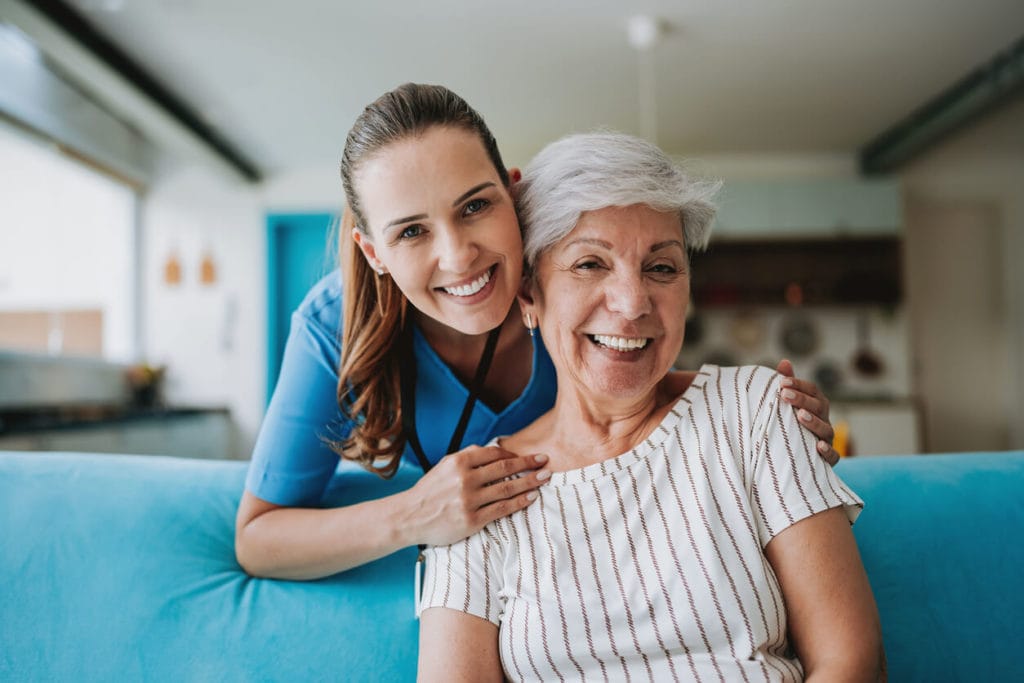 senior care healthcare professional hugging senior patient