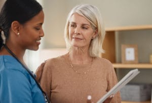 primary care doctor using a digital tablet during a consultation with a senior woman