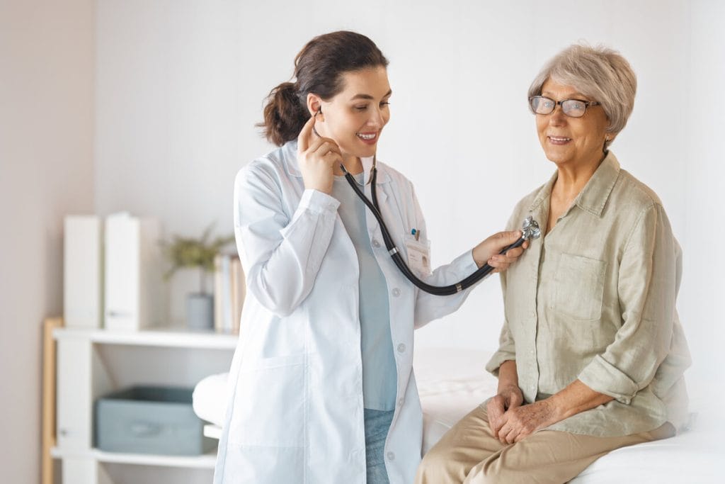 A senior patient with a doctor in medical office and getting screened during her Medicare Annual Wellness Visit.