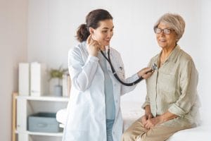 A senior patient with a doctor in medical office and getting screened during her Medicare Annual Wellness Visit.